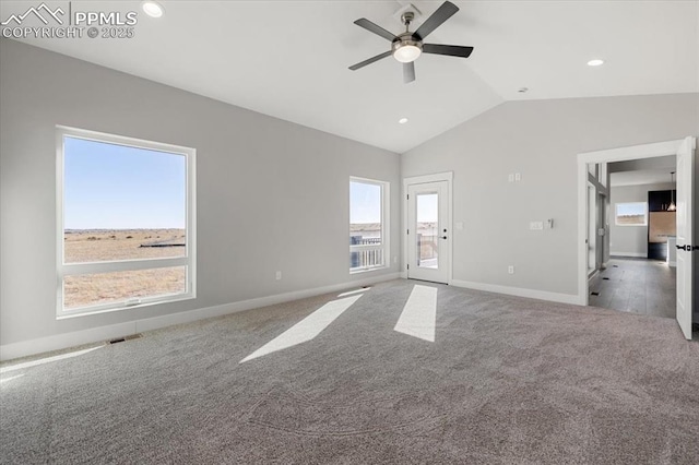 unfurnished living room with ceiling fan, light colored carpet, a healthy amount of sunlight, and vaulted ceiling