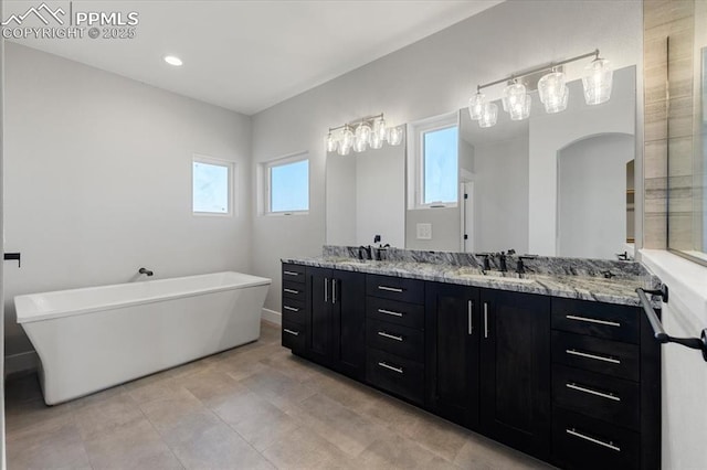 bathroom featuring tile patterned floors, a tub to relax in, and vanity