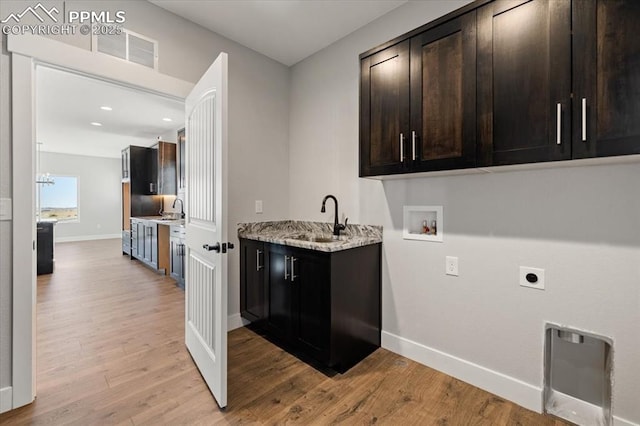 washroom with sink, electric dryer hookup, cabinets, washer hookup, and light hardwood / wood-style floors