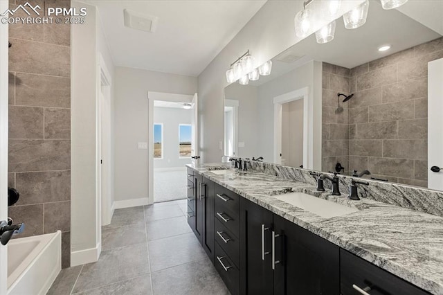 bathroom with tile patterned flooring, vanity, and tiled shower / bath combo