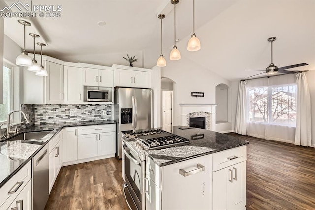 kitchen with pendant lighting, tasteful backsplash, white cabinetry, sink, and stainless steel appliances