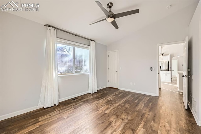 unfurnished bedroom featuring lofted ceiling, dark hardwood / wood-style floors, and ceiling fan