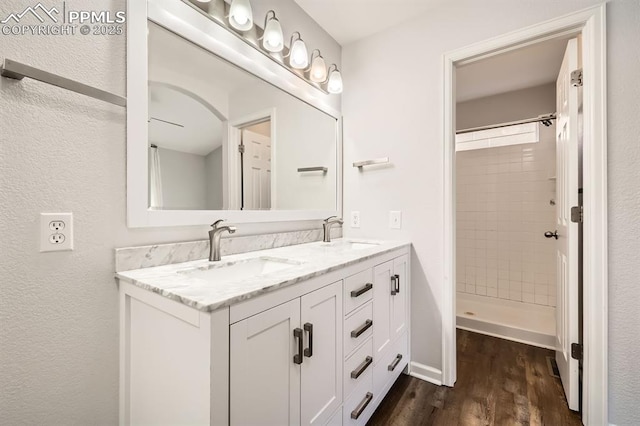 bathroom featuring vanity, hardwood / wood-style flooring, and tiled shower