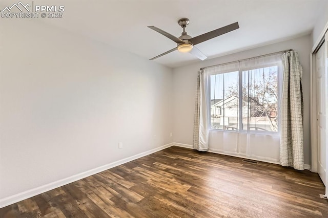 spare room featuring dark wood-type flooring and ceiling fan