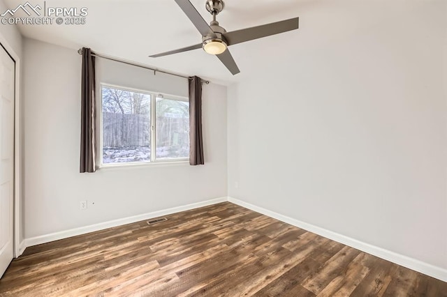 spare room featuring dark wood-type flooring and ceiling fan