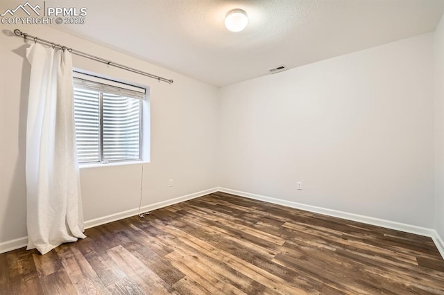 empty room featuring dark wood-type flooring