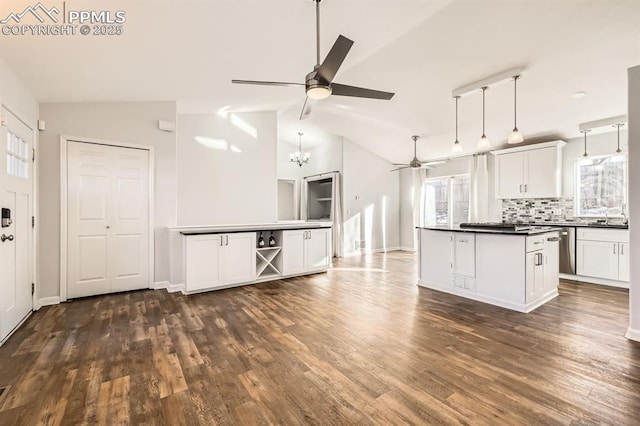 kitchen with tasteful backsplash, decorative light fixtures, vaulted ceiling, and white cabinets