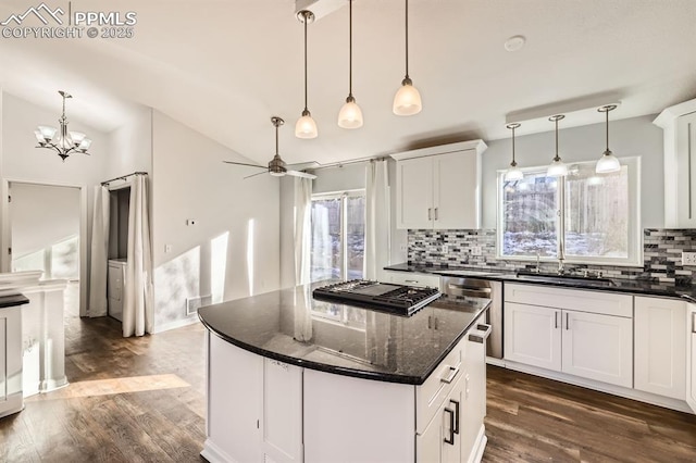 kitchen featuring white cabinetry, decorative backsplash, pendant lighting, and a kitchen island