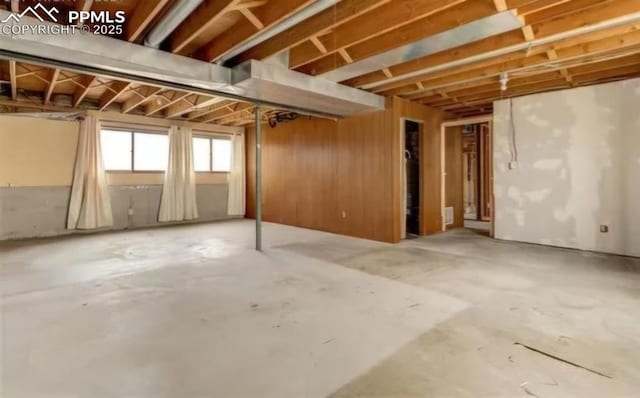 basement featuring wooden walls