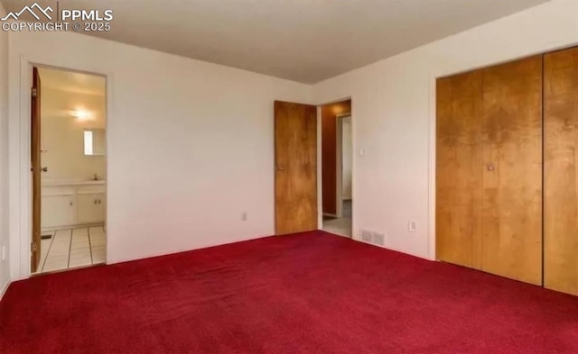 unfurnished bedroom featuring ensuite bathroom and a closet