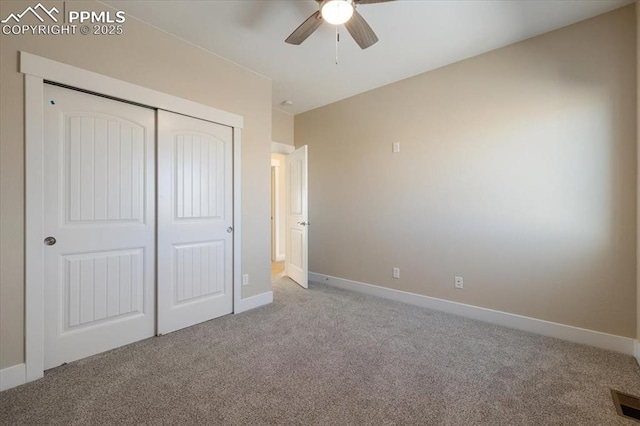 unfurnished bedroom featuring light colored carpet, ceiling fan, and a closet