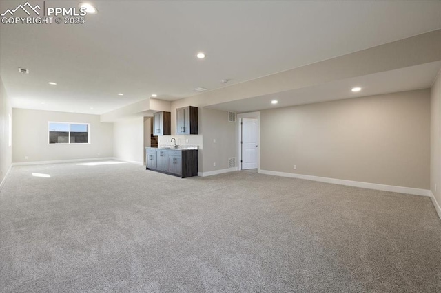 unfurnished living room featuring sink and light colored carpet