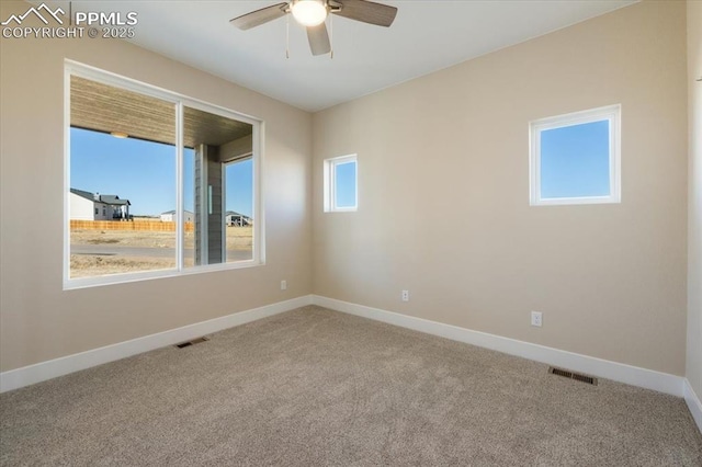 carpeted spare room featuring ceiling fan