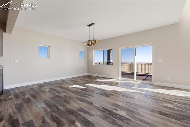 unfurnished dining area featuring dark hardwood / wood-style floors and a chandelier