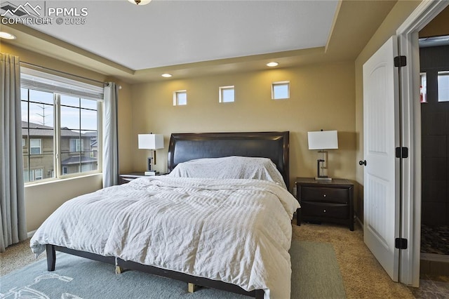 carpeted bedroom with a tray ceiling