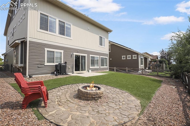 back of house featuring a yard, a patio area, and a fire pit