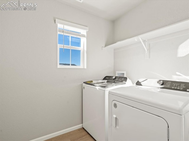 laundry area featuring independent washer and dryer and light hardwood / wood-style flooring