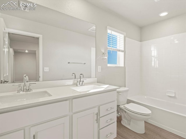 full bathroom featuring toilet, vanity, wood-type flooring, and washtub / shower combination