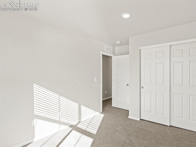 unfurnished bedroom with a closet and carpet flooring