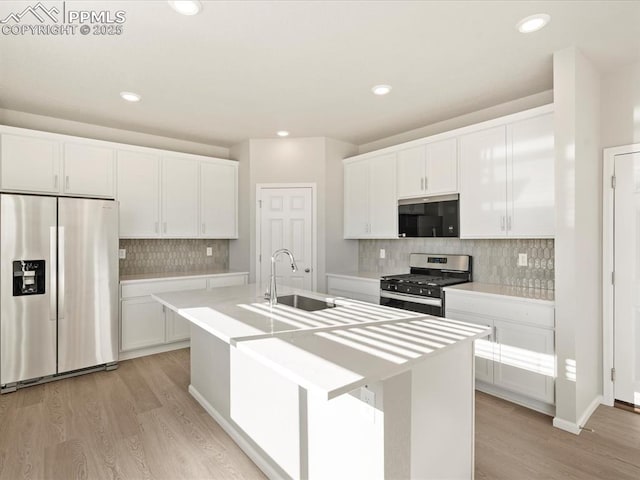 kitchen featuring sink, white cabinets, a center island with sink, and stainless steel appliances