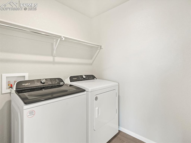 clothes washing area featuring washing machine and dryer and dark hardwood / wood-style flooring