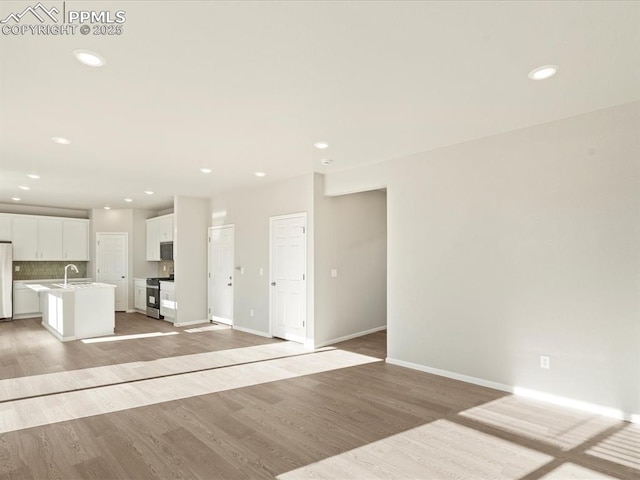 unfurnished living room with light wood-type flooring and sink