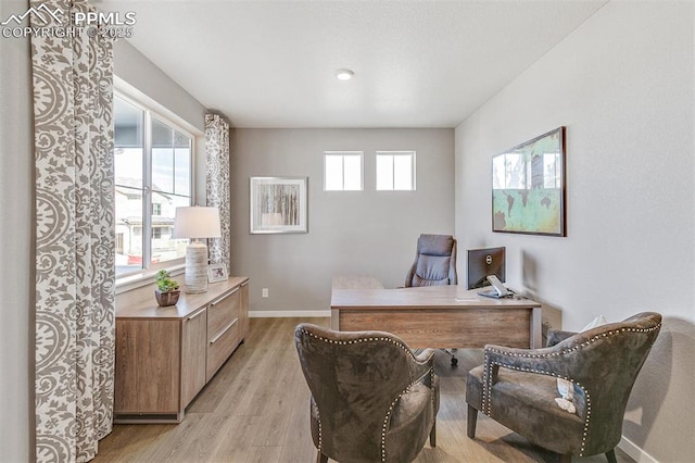 home office with light hardwood / wood-style flooring