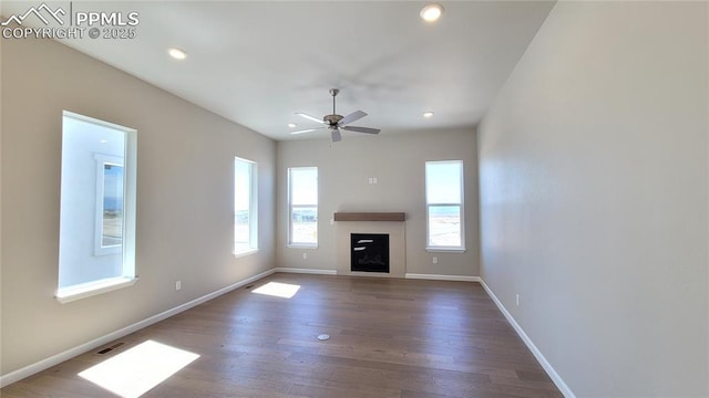 unfurnished living room featuring dark hardwood / wood-style flooring and ceiling fan