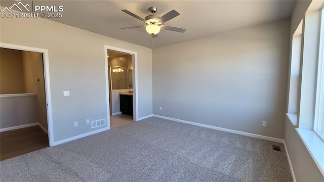 unfurnished bedroom featuring carpet, ensuite bath, and ceiling fan