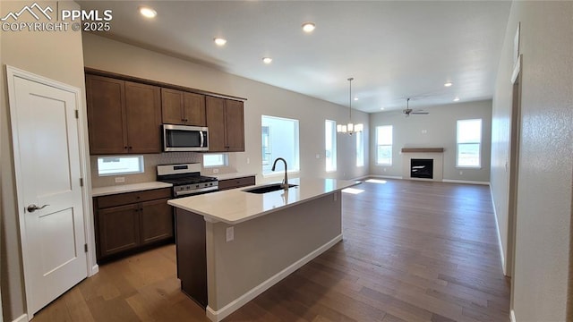 kitchen featuring hardwood / wood-style flooring, sink, appliances with stainless steel finishes, and an island with sink