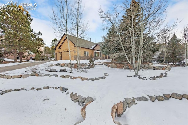 yard covered in snow featuring a garage