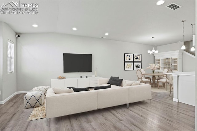 living room featuring light hardwood / wood-style flooring and an inviting chandelier