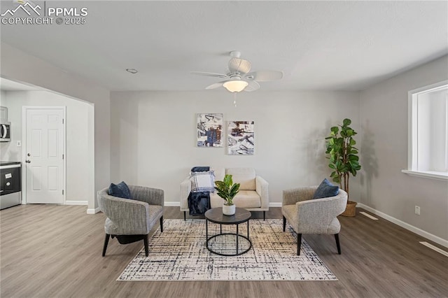 sitting room with ceiling fan and hardwood / wood-style floors