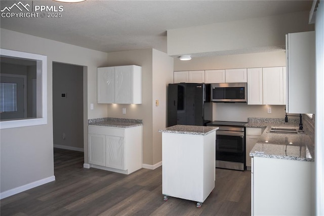 kitchen with stainless steel appliances, dark hardwood / wood-style floors, a kitchen island, sink, and white cabinetry