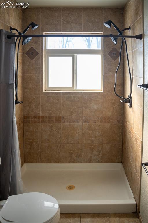 bathroom with toilet and a shower with curtain