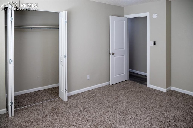 unfurnished bedroom with a closet and dark carpet