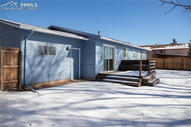 snow covered house with a wooden deck