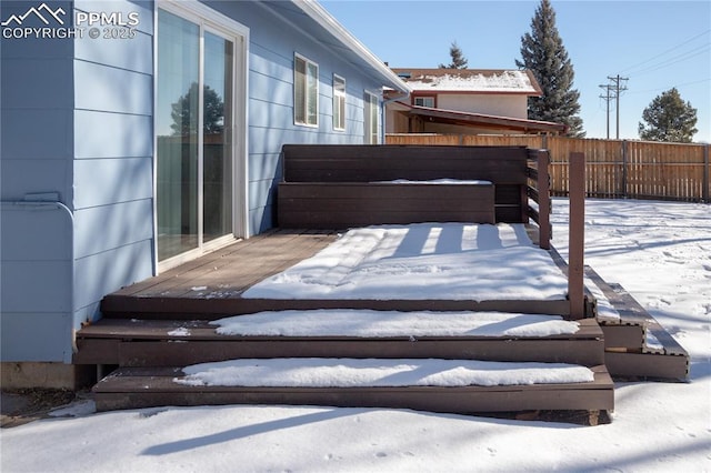 snow covered patio featuring a wooden deck