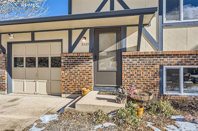 snow covered property entrance featuring a garage