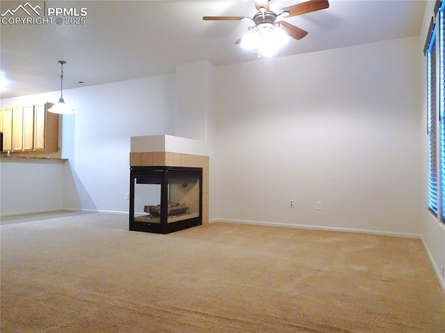 unfurnished living room with ceiling fan, light colored carpet, and a fireplace