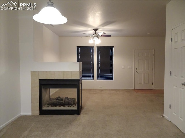 unfurnished living room featuring carpet flooring, ceiling fan, and a tiled fireplace