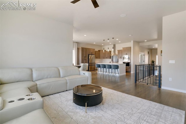 living room with light wood-style floors, recessed lighting, ceiling fan, and baseboards