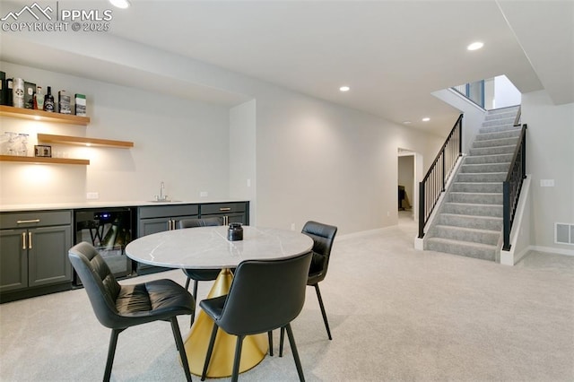 dining area with indoor wet bar, recessed lighting, light colored carpet, visible vents, and stairs