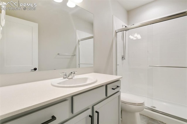 bathroom featuring vanity, toilet, and an enclosed shower