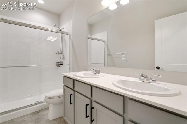 bathroom with vanity, toilet, and a shower with shower door