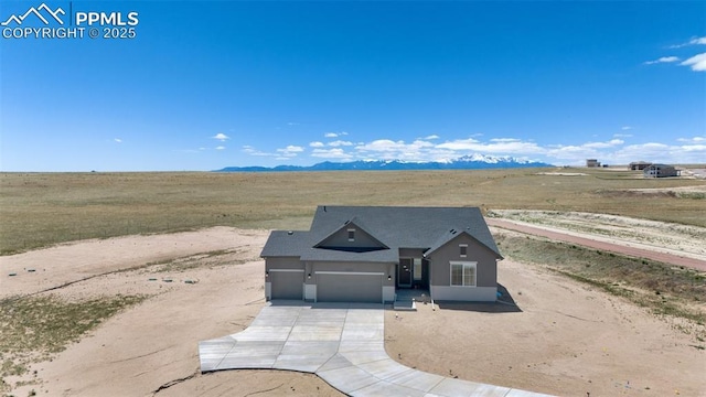 view of front of property featuring a mountain view, a rural view, and a garage