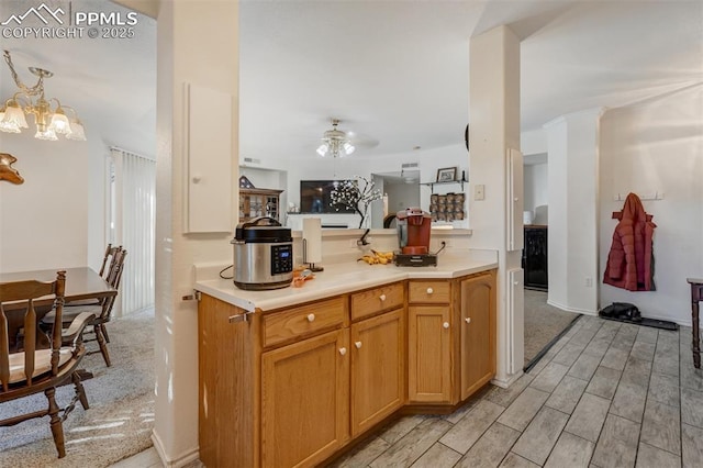 kitchen with ceiling fan with notable chandelier and pendant lighting