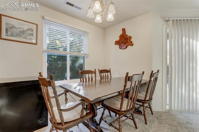 dining area featuring carpet flooring and a notable chandelier