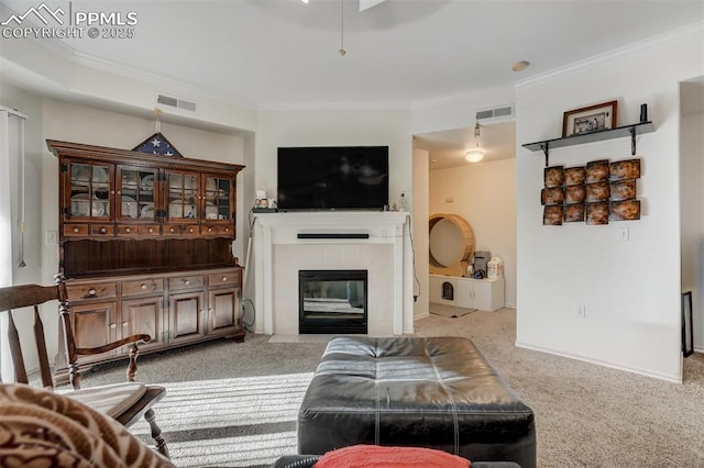 carpeted living room featuring a tile fireplace and ornamental molding