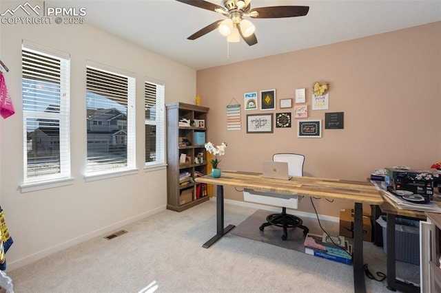 carpeted office space featuring ceiling fan and a healthy amount of sunlight